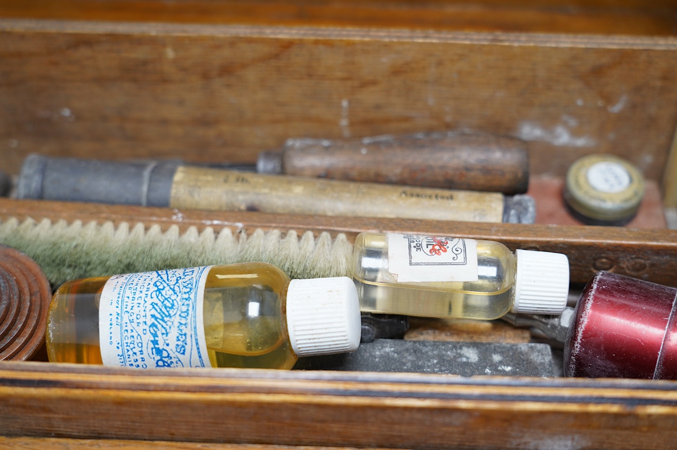 A collection of watch parts, tools and a small selection of costume jewellery, housed in two cases, together with two books. Condition - poor to fair